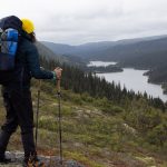 femme en randonnée avec sac à dos devant paysage monts-groulx