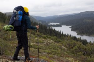 femme en randonnée avec sac à dos devant paysage monts-groulx