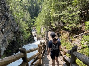 Femme de dos qui descend les escaliers à côté d'une chute d'eau