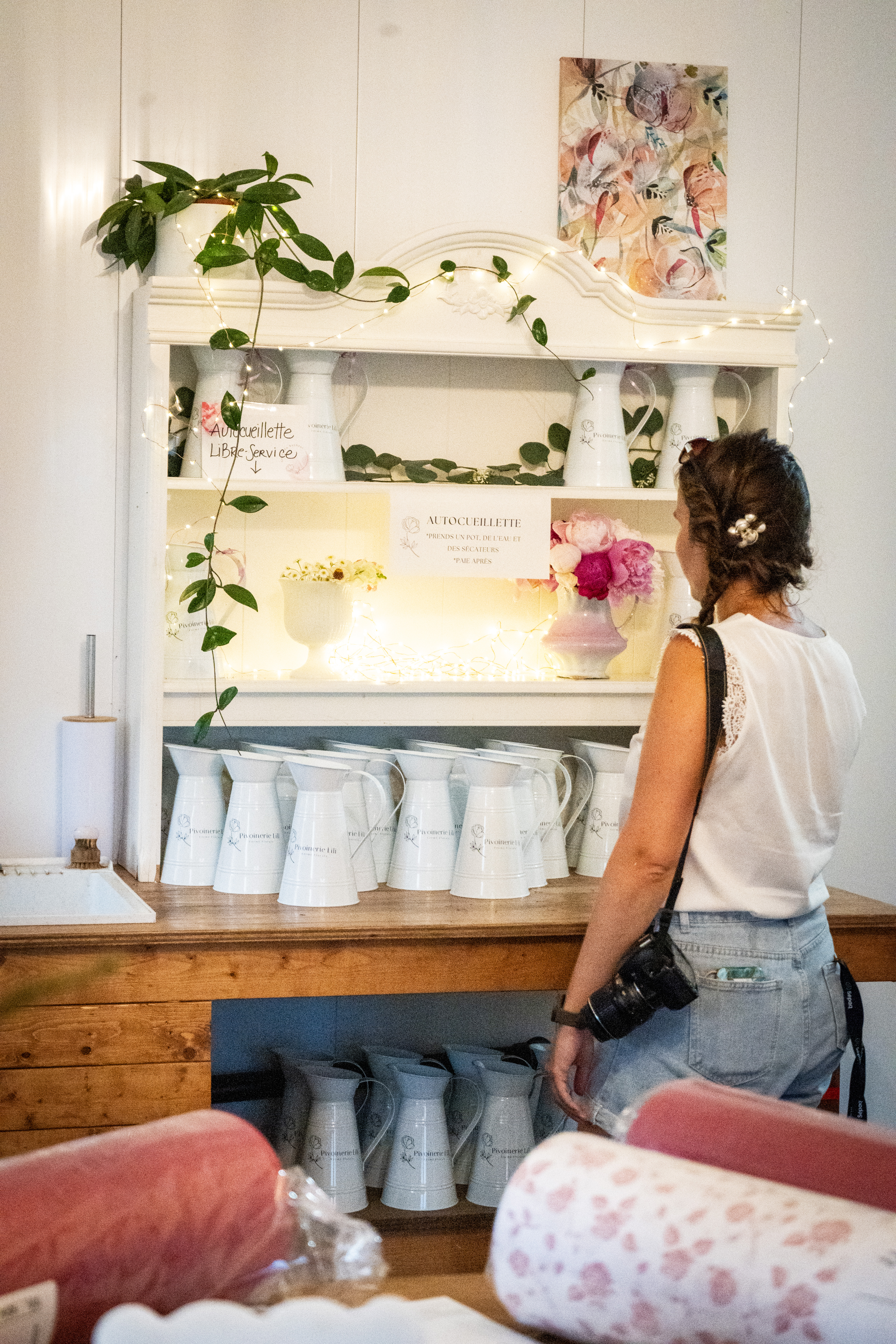 Une photographe de dos regarde des fleurs chez Pivoinerie Lili